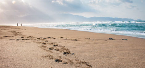 Couple walking on beach at sunset